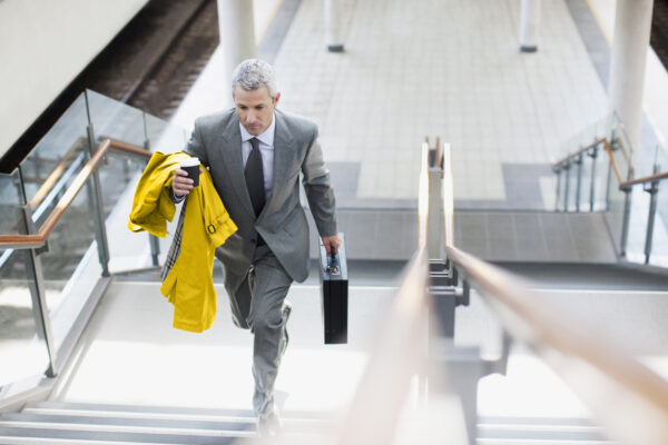 Businessman walking up stairs in train station